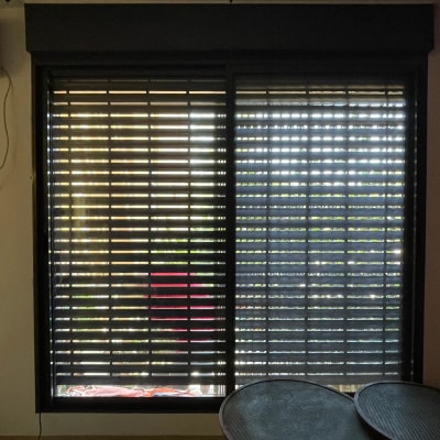 תריסי אלומיניום סגורים על חלון זכוכית