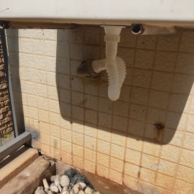 צינור פלסטיק לבן מחובר לקיר אריחים