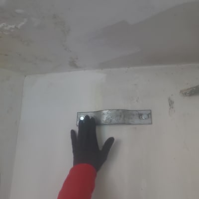 יד עם כפפה נוגעת במתכת על קיר