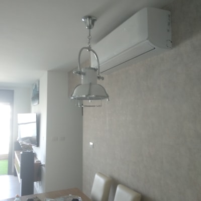 מזגן מותקן על קיר בחדר עם מנורה תלויה