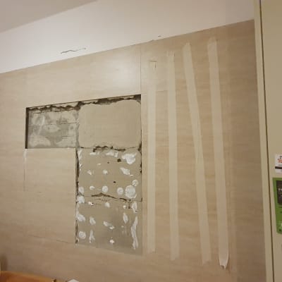 קיר עם אריחים שבורים ותיקוני טיח