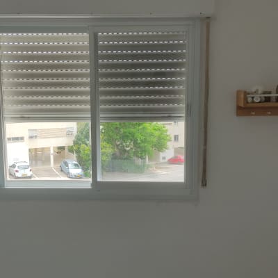 חלון אלומיניום עם תריסים סגורים למחצה