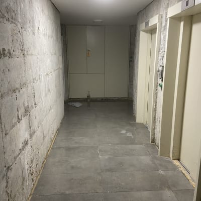 מסדרון עם קירות חשופים ורצפת אריחים חדשה