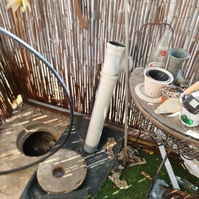 כלי עבודה וצינור ליד פתח ביוב