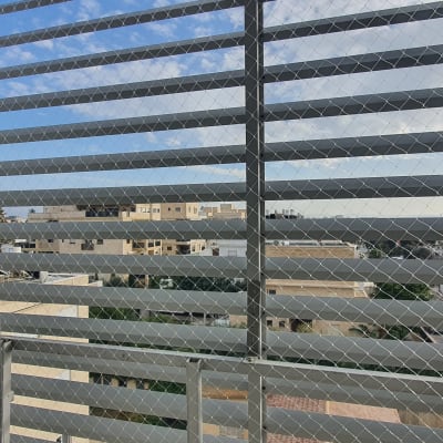 רשת מתכת על חלון למניעת כניסת יונים