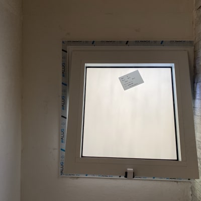 חלון אלומיניום עם מסגרת לבנה ותווית על הזכוכית