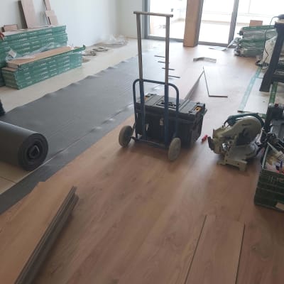 התקנת פרקט עץ עם כלים וחומרים על הרצפה