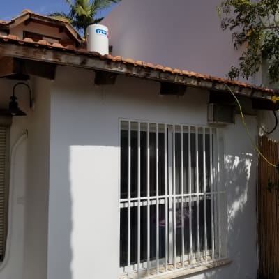 חלון עם סורגים לבנים על קיר חיצוני