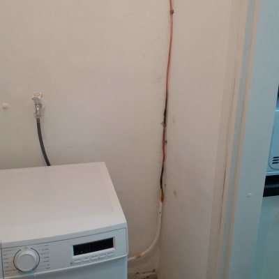 מכונת כביסה עם צינור גז מחובר לקיר