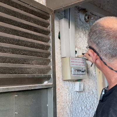 חשמלאי בודק לוח חשמל עם מפסקים