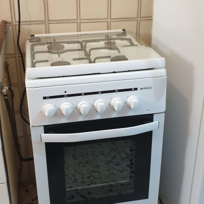 תנור גז לבן עם כפתורים ומכסה זכוכית