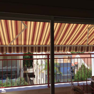 סוככים מפוספסים בצבעים חום וצהוב על מרפסת