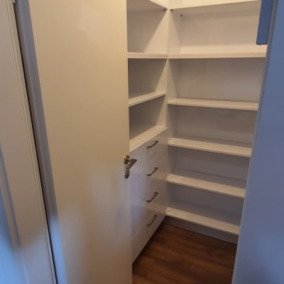 ארון מדפים לבן עם מגירות ודלת פתוחה