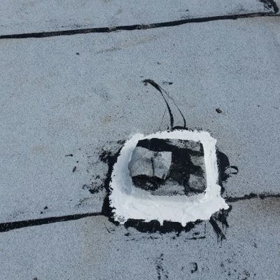 איטום גג עם חומר לבן ושחור סביב חור