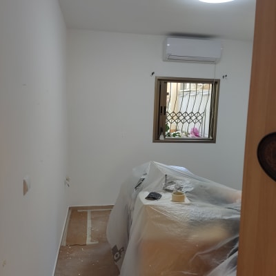 חדר עם קירות צבועים, רהיטים מכוסים בניילון