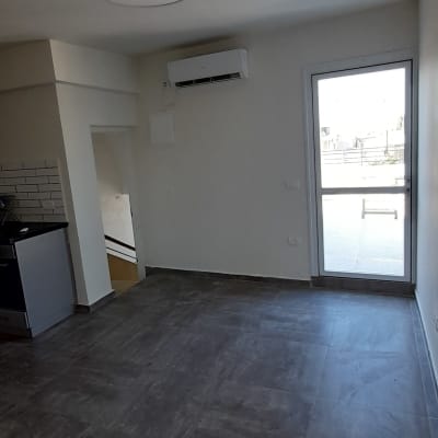 חדר עם רצפת אריחים, קיר לבן ומזגן