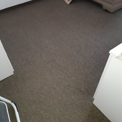 שטיח חום בחדר עם ספה בפינה