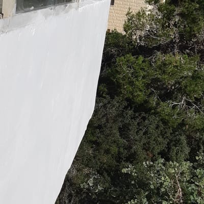 קיר חיצוני אטום בצבע לבן ליד חלון