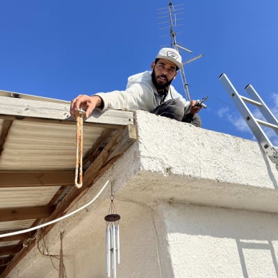 אדם על גג עם אנטנה וסולם לידו