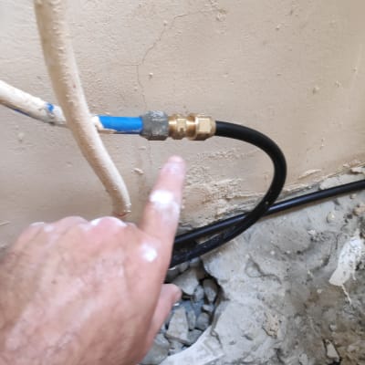 יד מצביעה על חיבור צינור מים עם מחבר מתכת