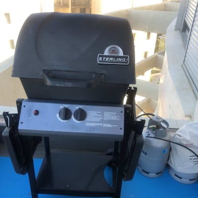 גריל גז עם כפתורים ומיכל גז בצד