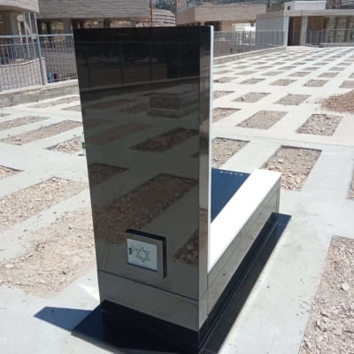 מצבה שחורה עם מגן דוד בבית קברות