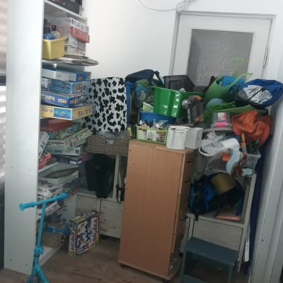 מדפים עם משחקי קופסה, ארגזים וקטנוע כחול