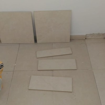 אריחים מונחים על הרצפה ליד שק מלט פתוח