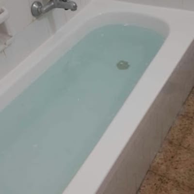 אמבטיה מלאה במים עם ברז קיר