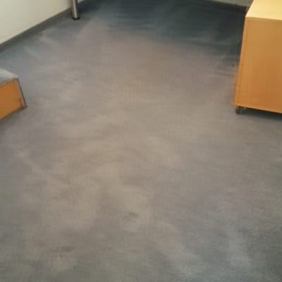 שטיח אפור נקי בחדר עם שולחן עץ