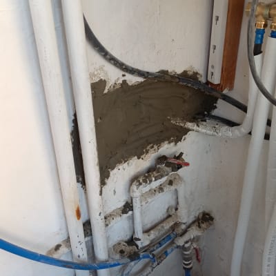 צינורות מים ותיקון קיר בטון עם טיח