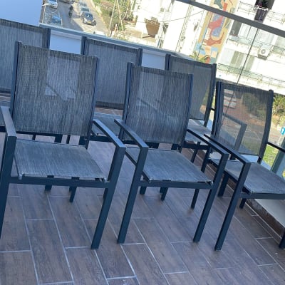 שישה כיסאות מתכת עם מושב ורשת על מרפסת