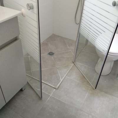 מקלחון זכוכית עם רצפת אריחים אפורים