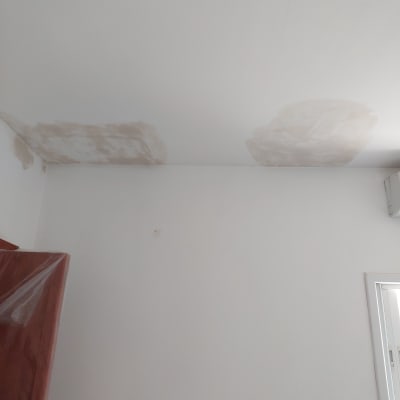 תיקוני טיח בתקרה לבנה עם כתמים