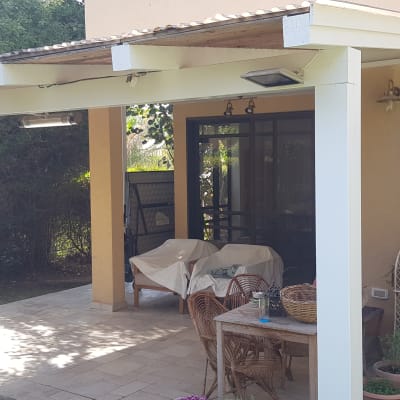 פרגולה מעץ לבן עם שולחן וכיסאות עץ