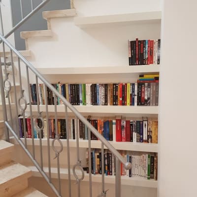מדפי עץ מתחת למדרגות עם ספרים