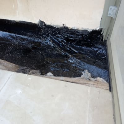 איטום עם חומר שחור על קיר ורצפה