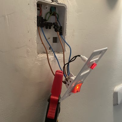 חוטי חשמל מחוברים לשקע בקיר עם כלי עבודה