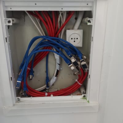 כבלים כחולים ואדומים מחוברים לשקע חשמל בקיר