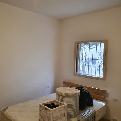 חדר עם קירות צבועים בלבן ומיטה