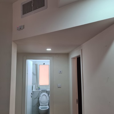 קירות גבס לבנים עם פתחי אוורור ותקרה משופעת