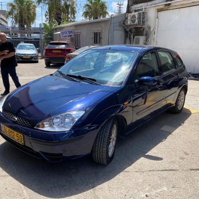 מכונית כחולה בחניון מוסך עם לוחית רישוי צהובה