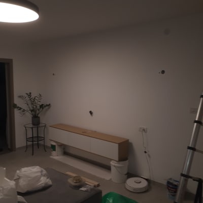 קיר לבן עם חורים, דלי צבע ומברשת