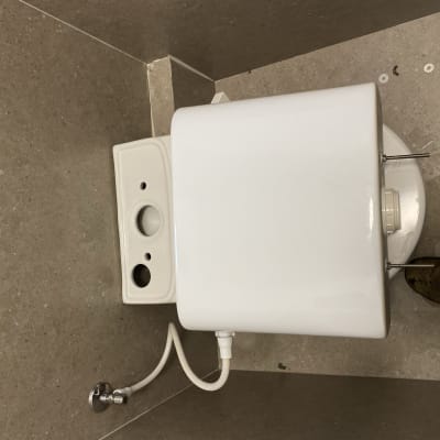 מיכל מים עם צינור וכלי עבודה על הרצפה