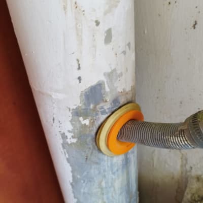 צינור מתכת מחובר לקיר עם אטם כתום