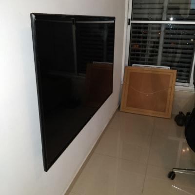 טלוויזיה תלויה על קיר עם כבל חשמל