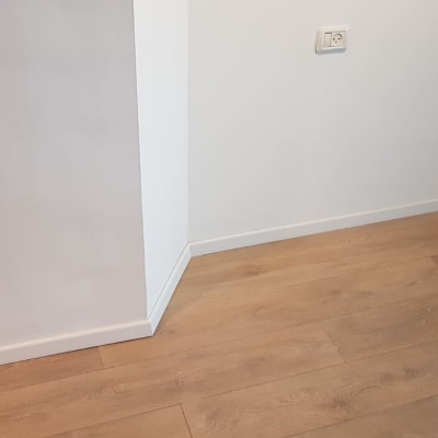 רצפת פרקט עץ בהירה ליד קיר לבן