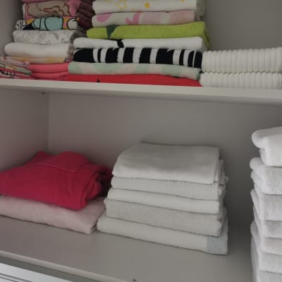 מגבות מקופלות בארון מסודר בשתי קומות