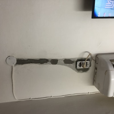 שקע חשמל פתוח עם חוטים ליד מזגן על קיר