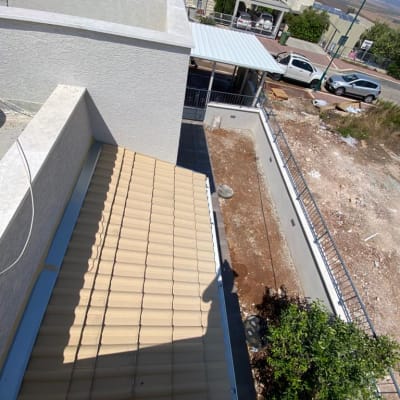 גג רעפים חום עם צל של אדם על קיר